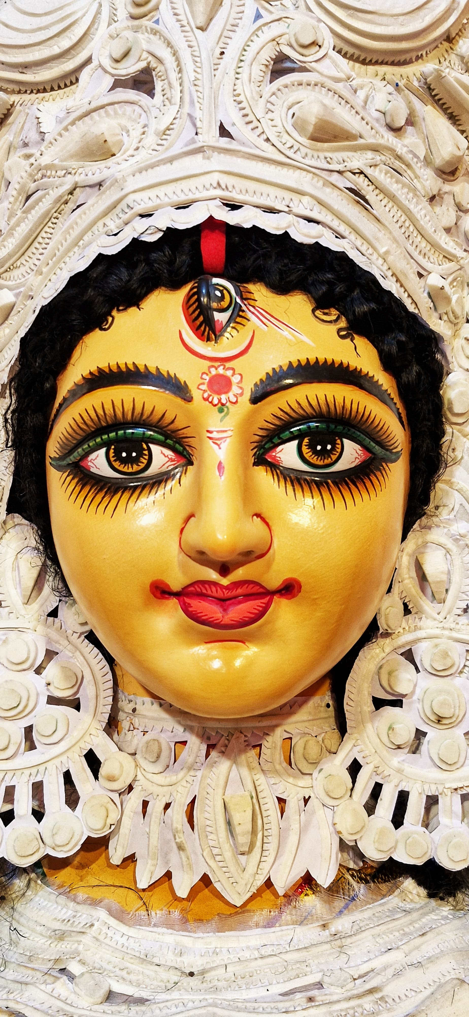 Statue of the Goddess Durga wearing an elaborate headdress, showcasing intricate details and artistic craftsmanship.