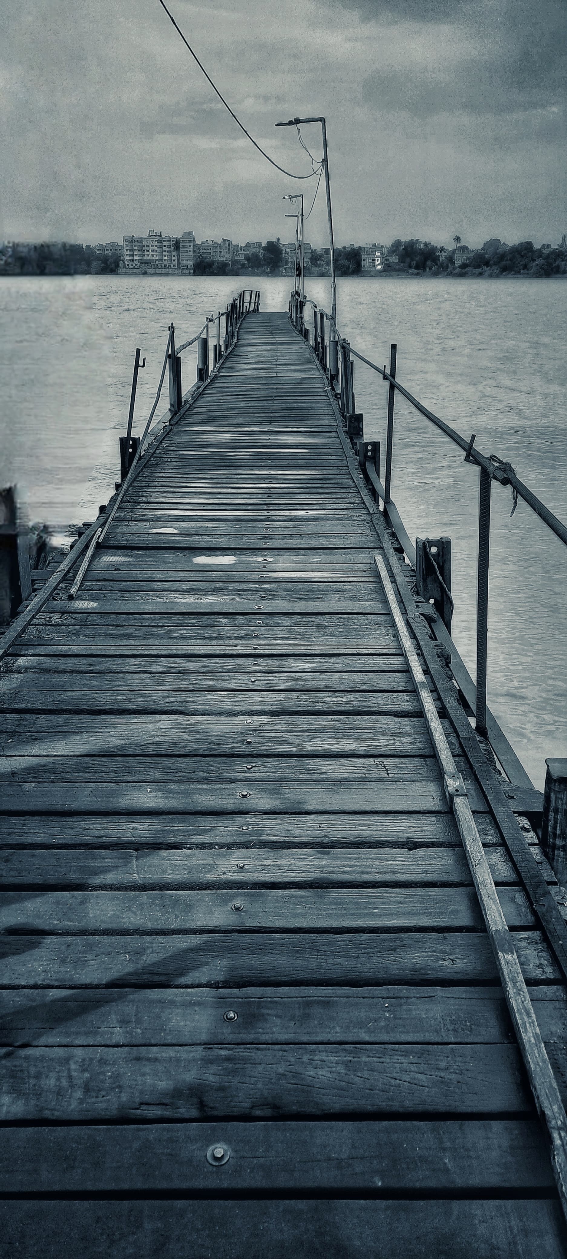 A wooden pier extends over water, surrounded by a serene natural setting.